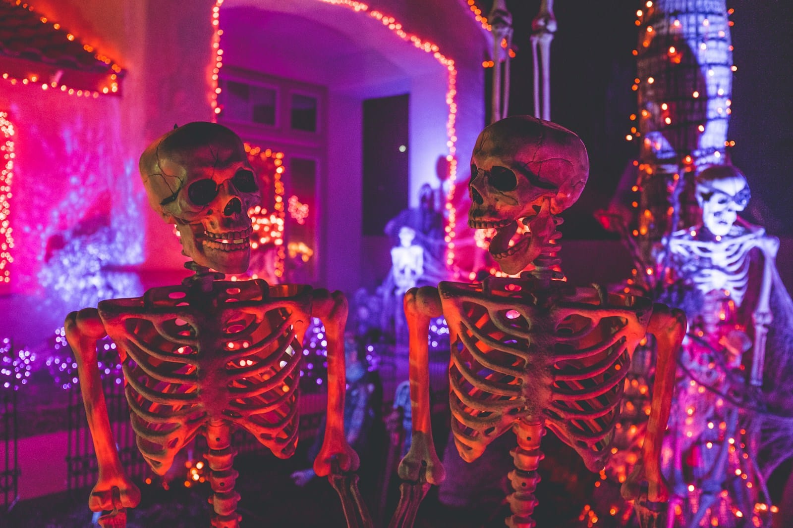 Décoration Halloween avec citrouilles sculptées et lumières orangées.